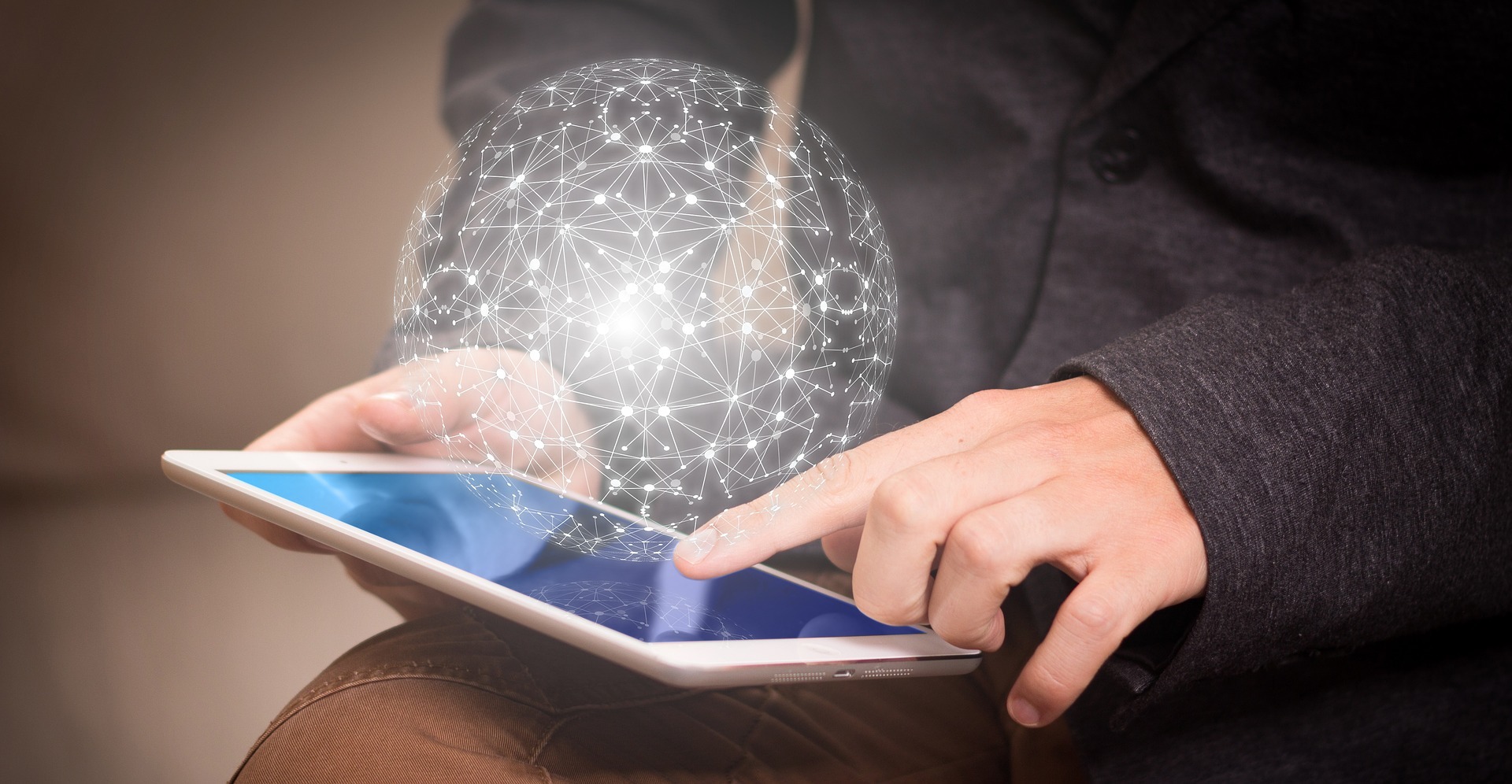 Hand holding a tablet with a global network overlay